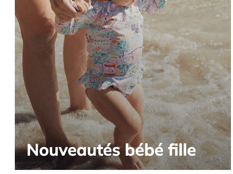 Little girl in pink striped ruffled swimsuit holding lollipop on sunny beach