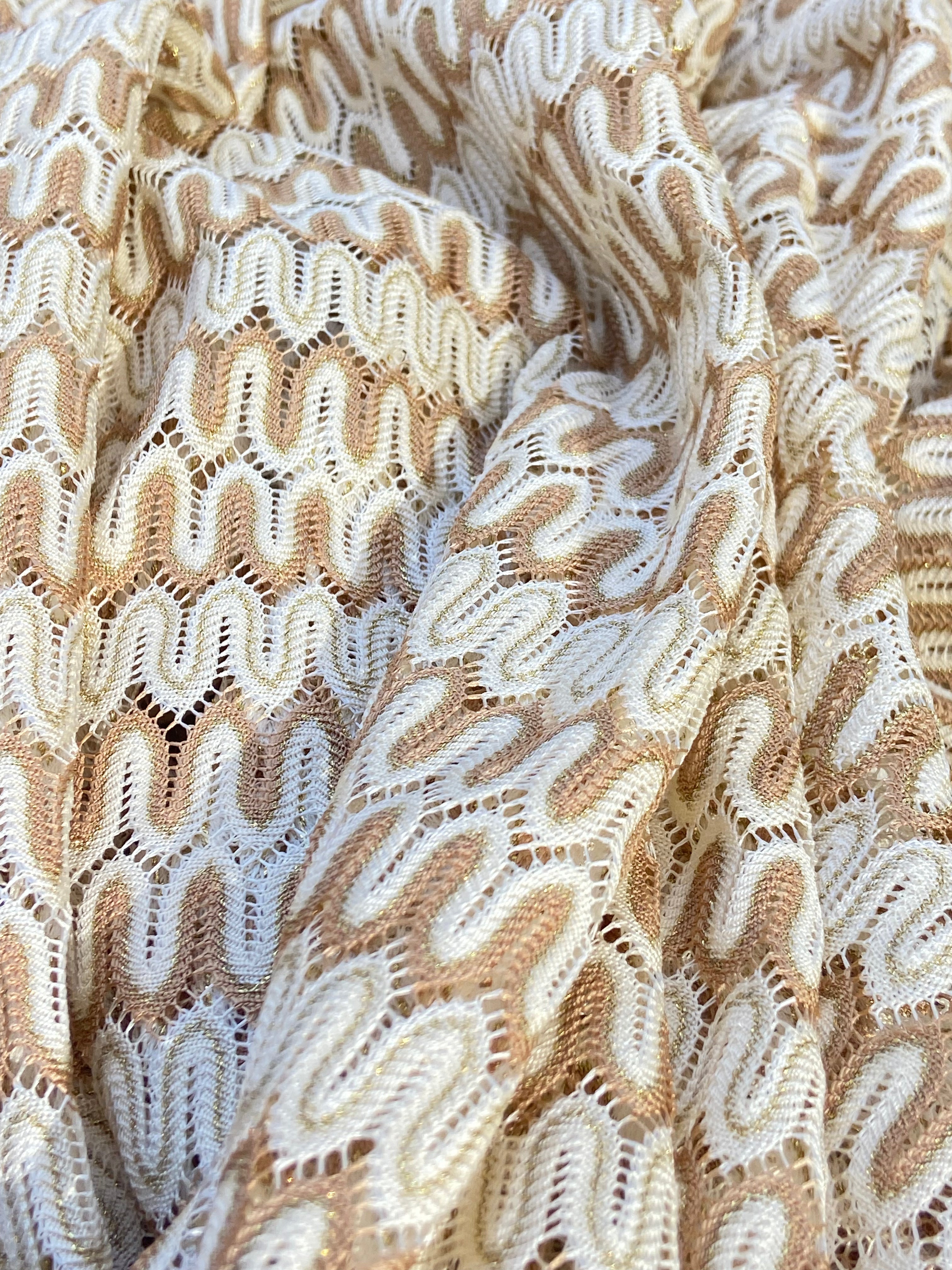 Close-up of white and gold crochet bikini fabric, wavy pattern, Lison Paris beachwear
