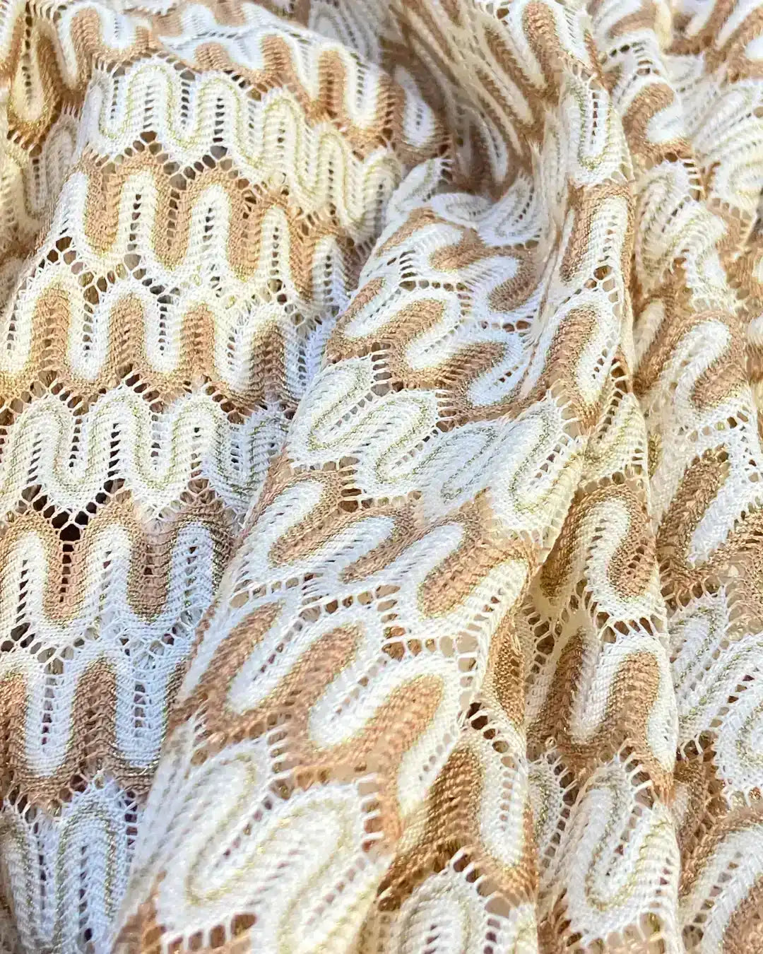 White and gold crochet fabric detail from Lison Paris girls’ caftan, beachwear textile.