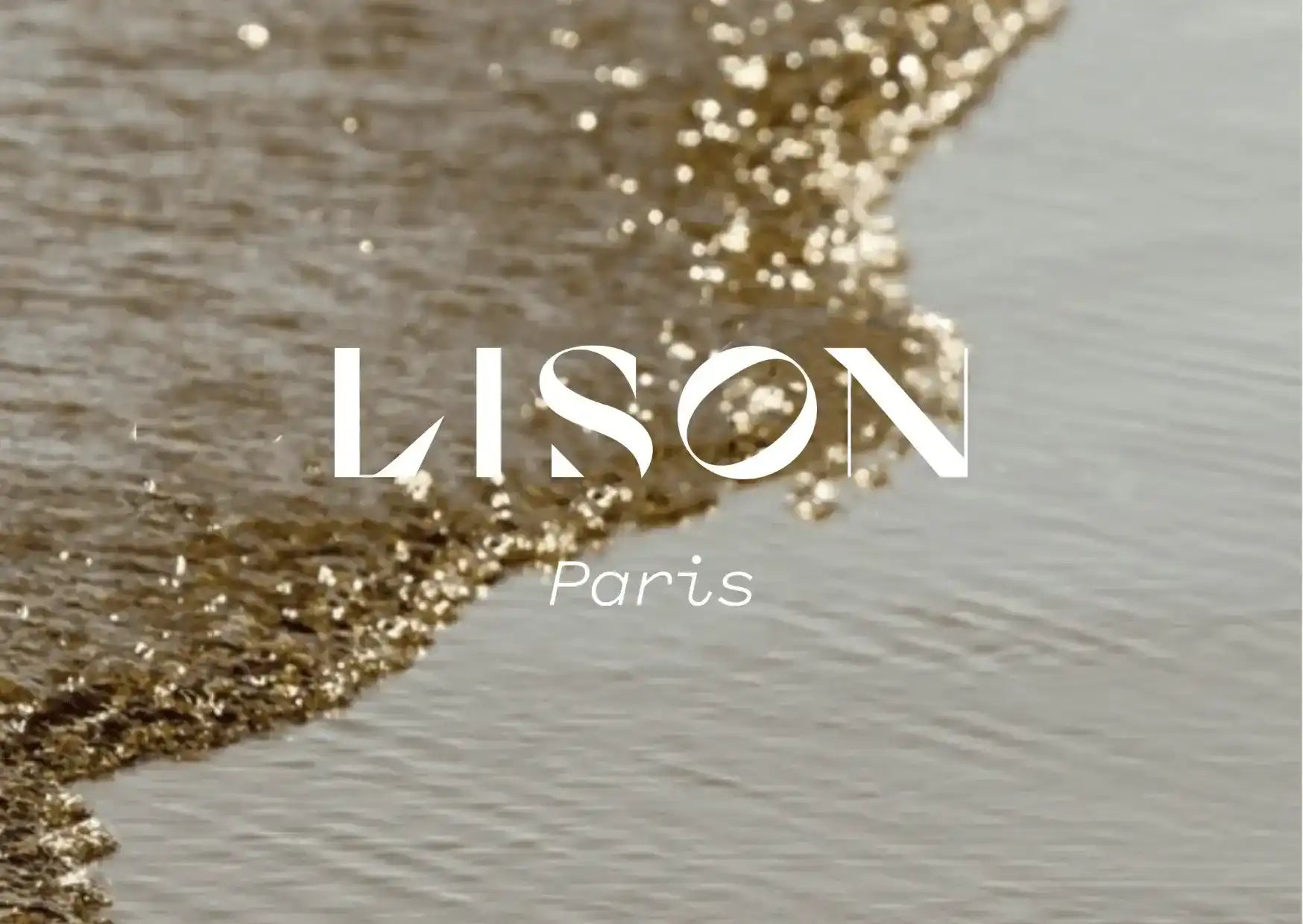 Beach shoreline with gentle waves, white LISON Paris text overlay
