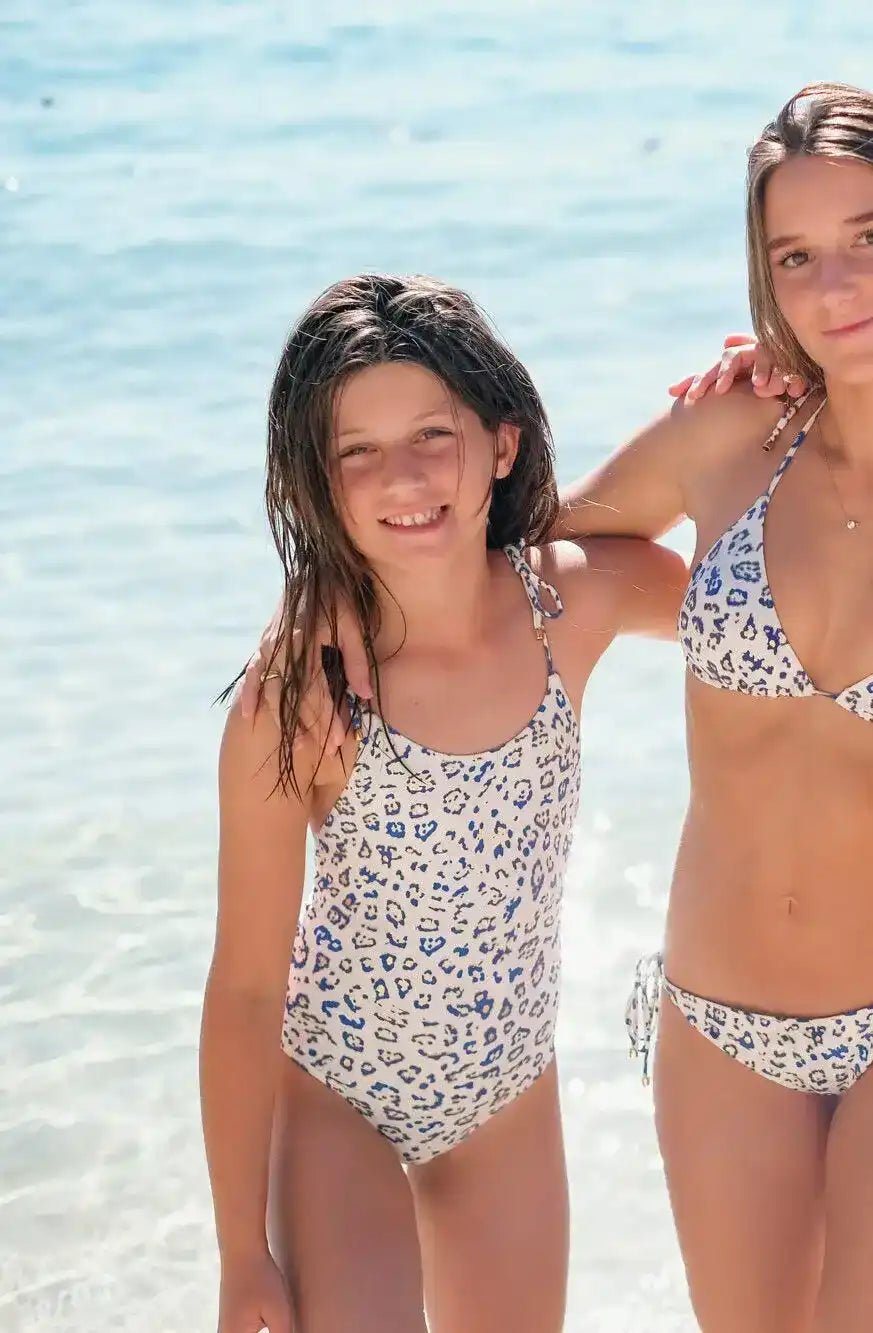 Girl wearing blue and gold leopard print one-piece swimsuit on the beach