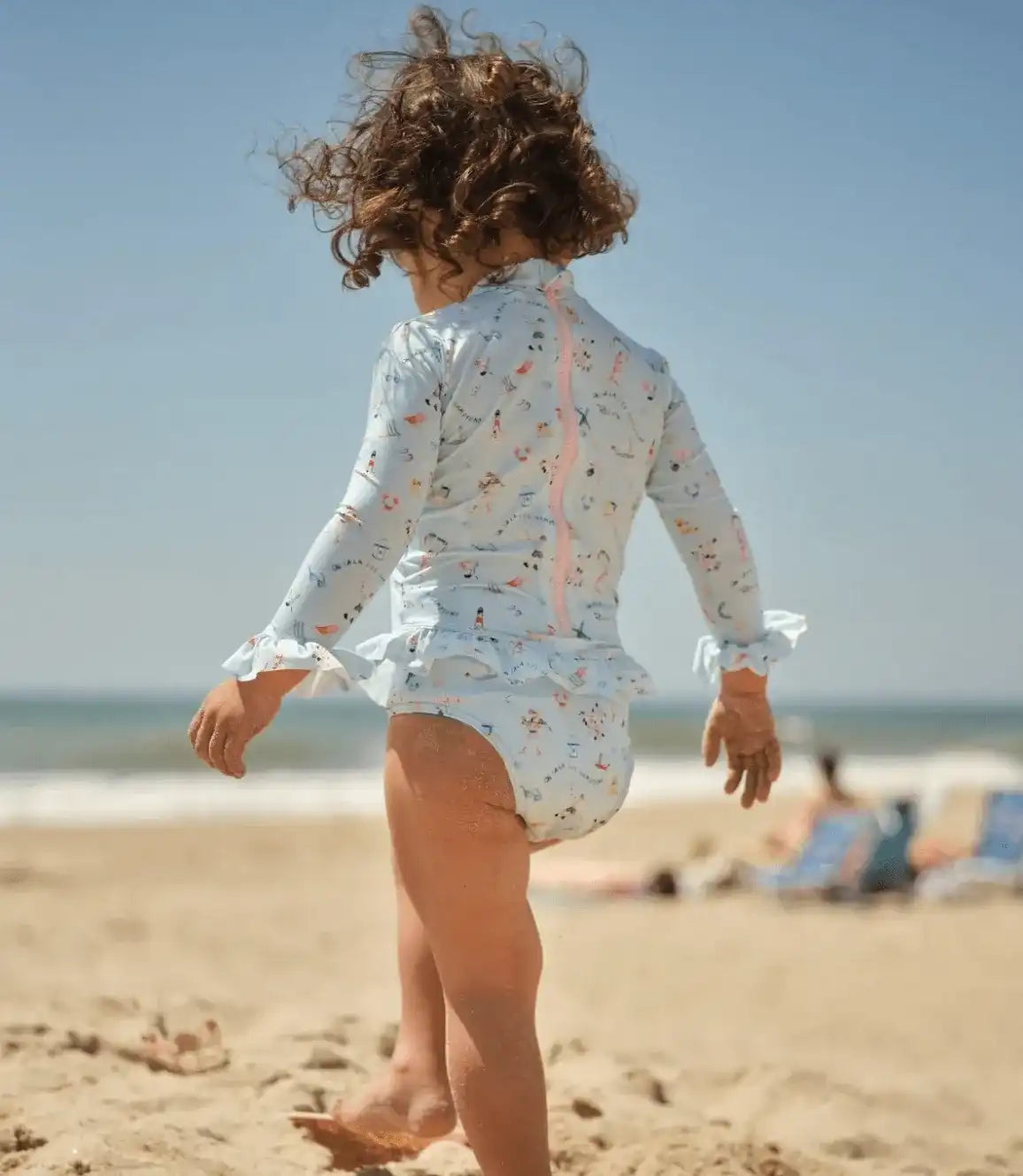 Girl wearing Lison Paris long-sleeve anti-UV swimsuit at the beach