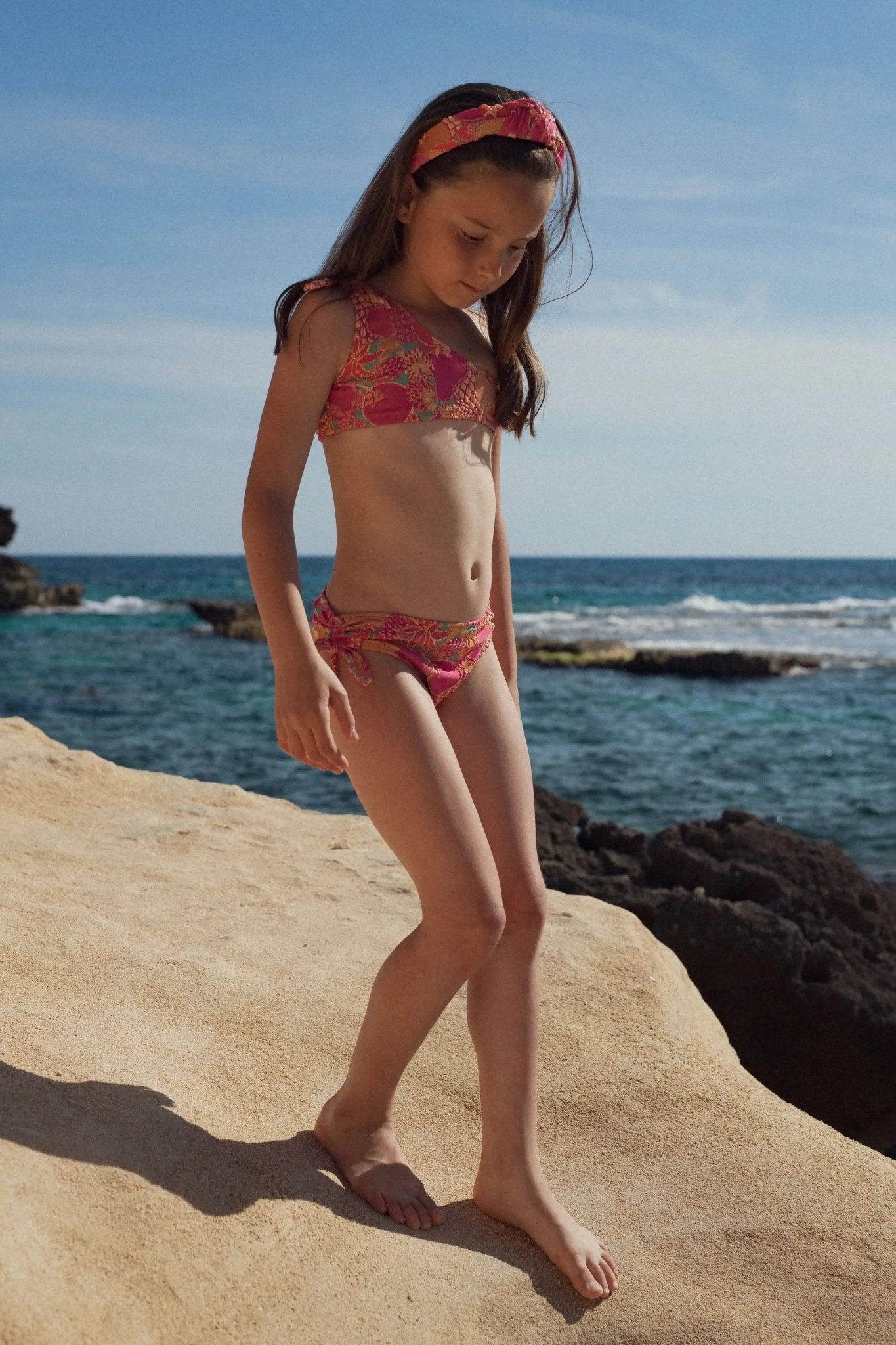 Girl wearing a colorful bikini and matching headband on a sunny beach