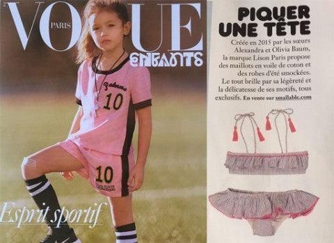 Young girl in pink sporty outfit and striped socks, Vogue Enfants magazine cover with swimwear feature.